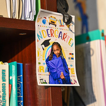 Photo of a student hanging up on a bookshelf. Read about What to Give Photo of a student hanging up on a bookshelf. Read about What to Give