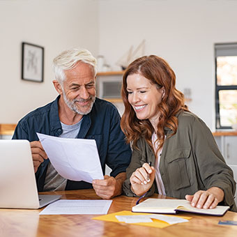 Couple sitting down with a laptop and paperwork. Read about Tangible Personal Property Couple sitting down with a laptop and paperwork. Read about Tangible Personal Property